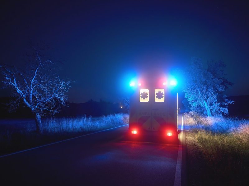 Ambulance car of emergency medical service on road at night. Themes rescue, urgency and health care.