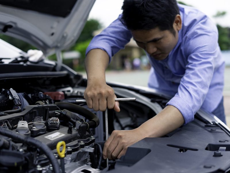 The male mechanic's hand holds the wrench In order to fix And check car engine, engineer concept and car repair