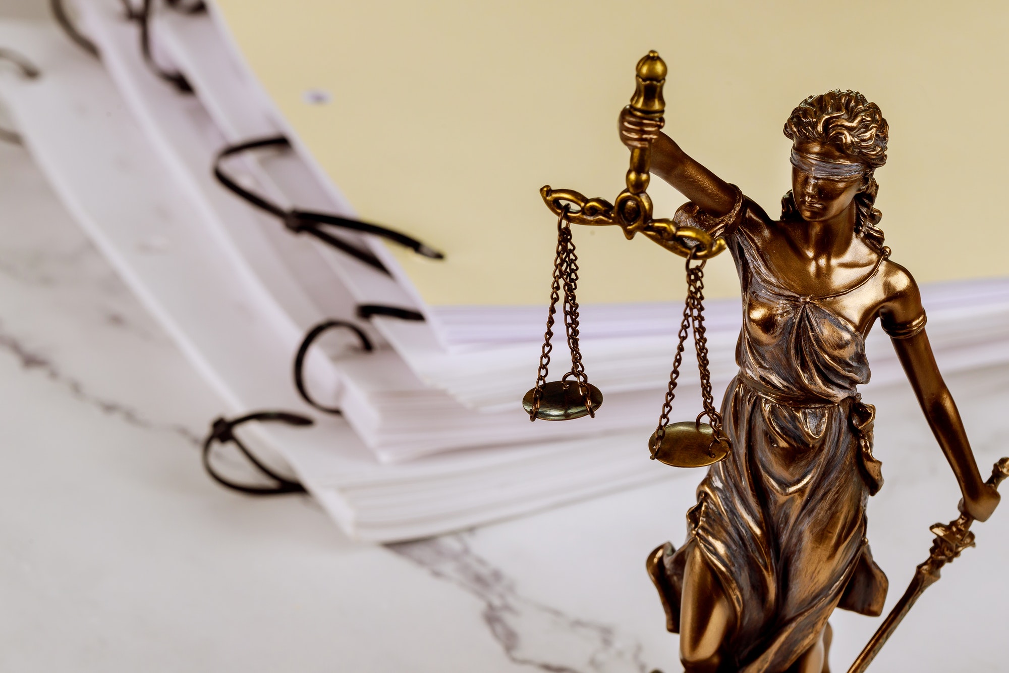 Justice statue with document folders standing, administration workplace