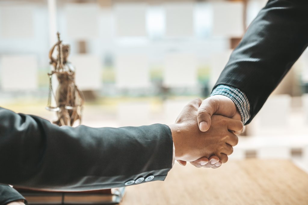 Lawyers shake hands with clients who come to testify in the case.